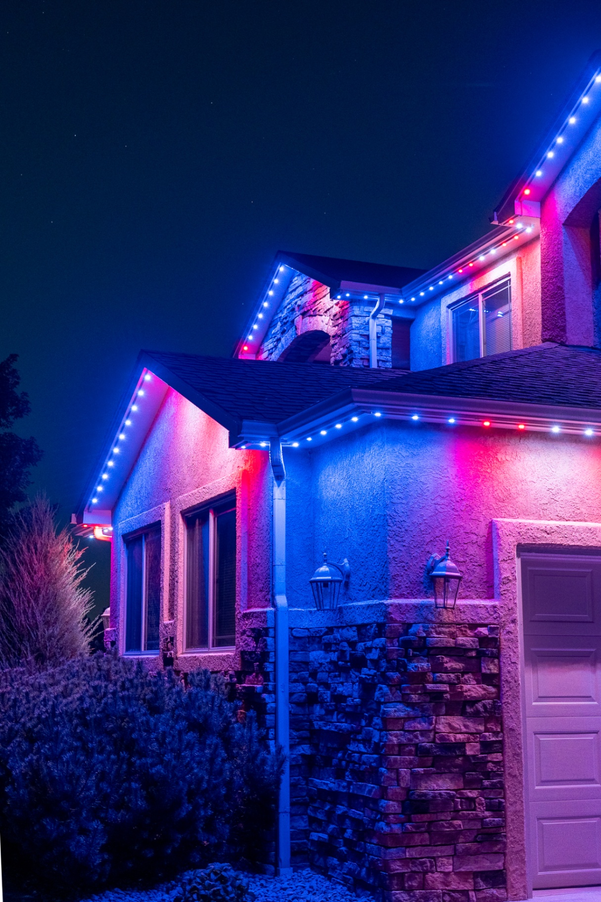 Red and blue lighting on a stucco two-story home