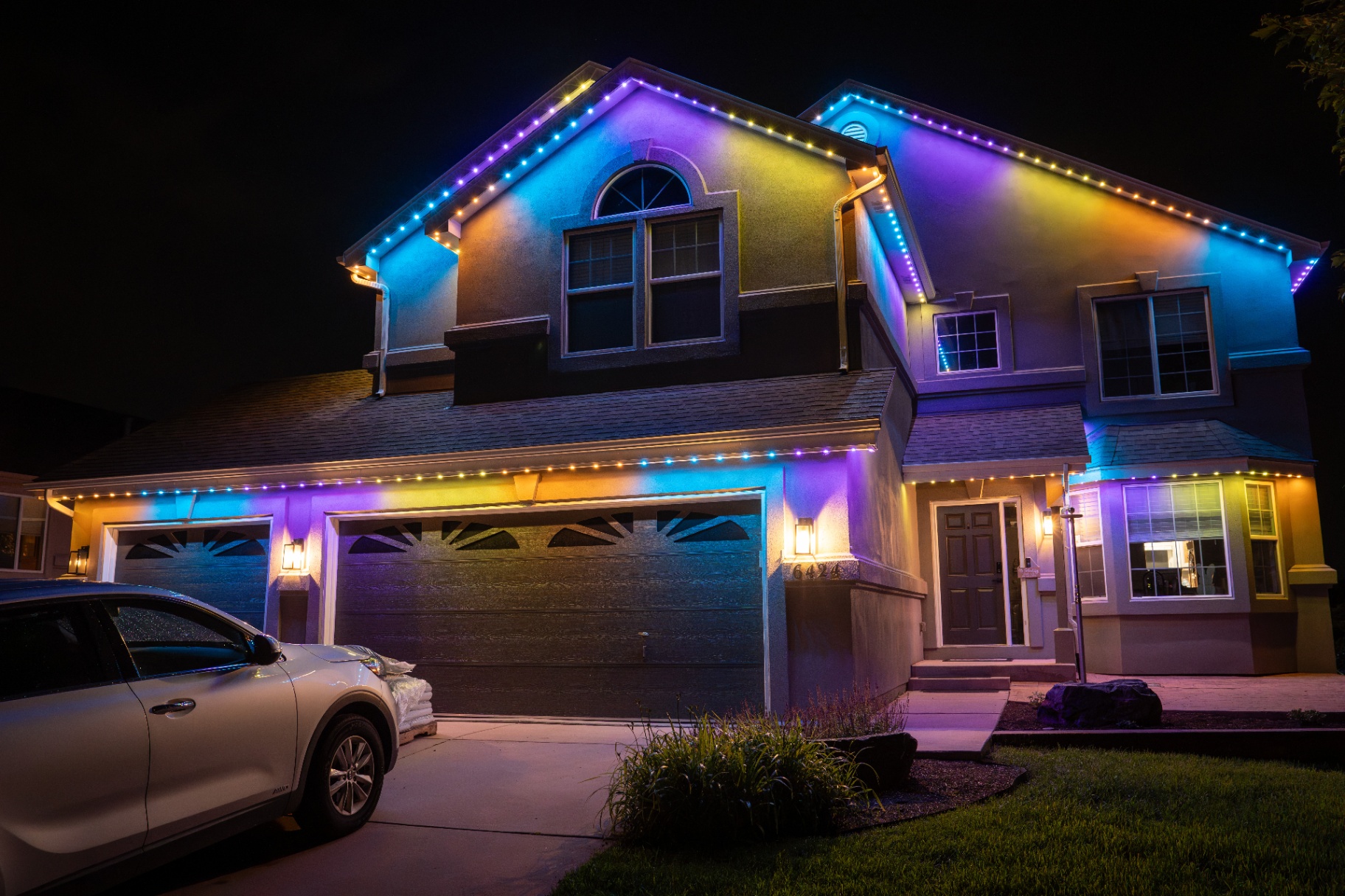 Blue, purple, and yellow holiday lights on a home