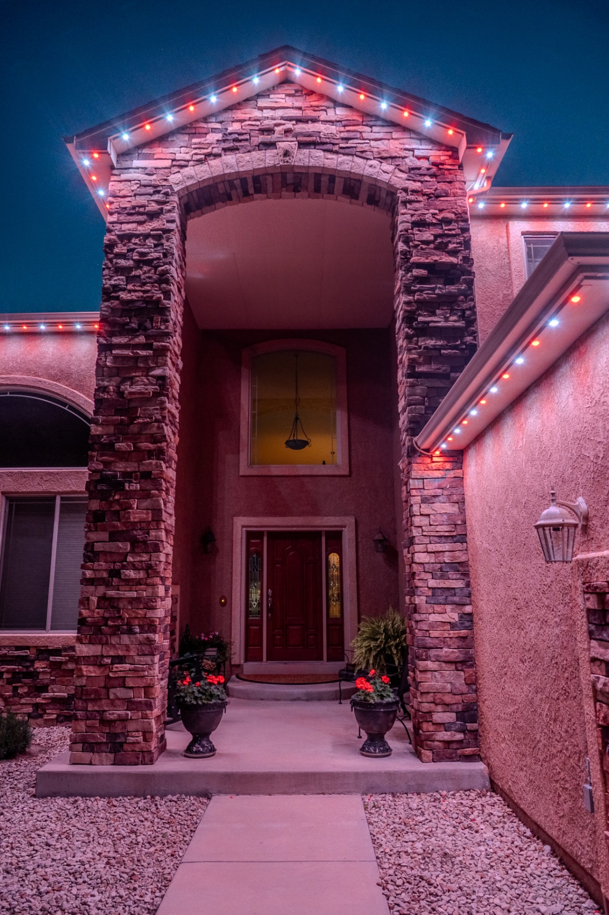 Red, white, and blue patriotic lighting on a stone entryway