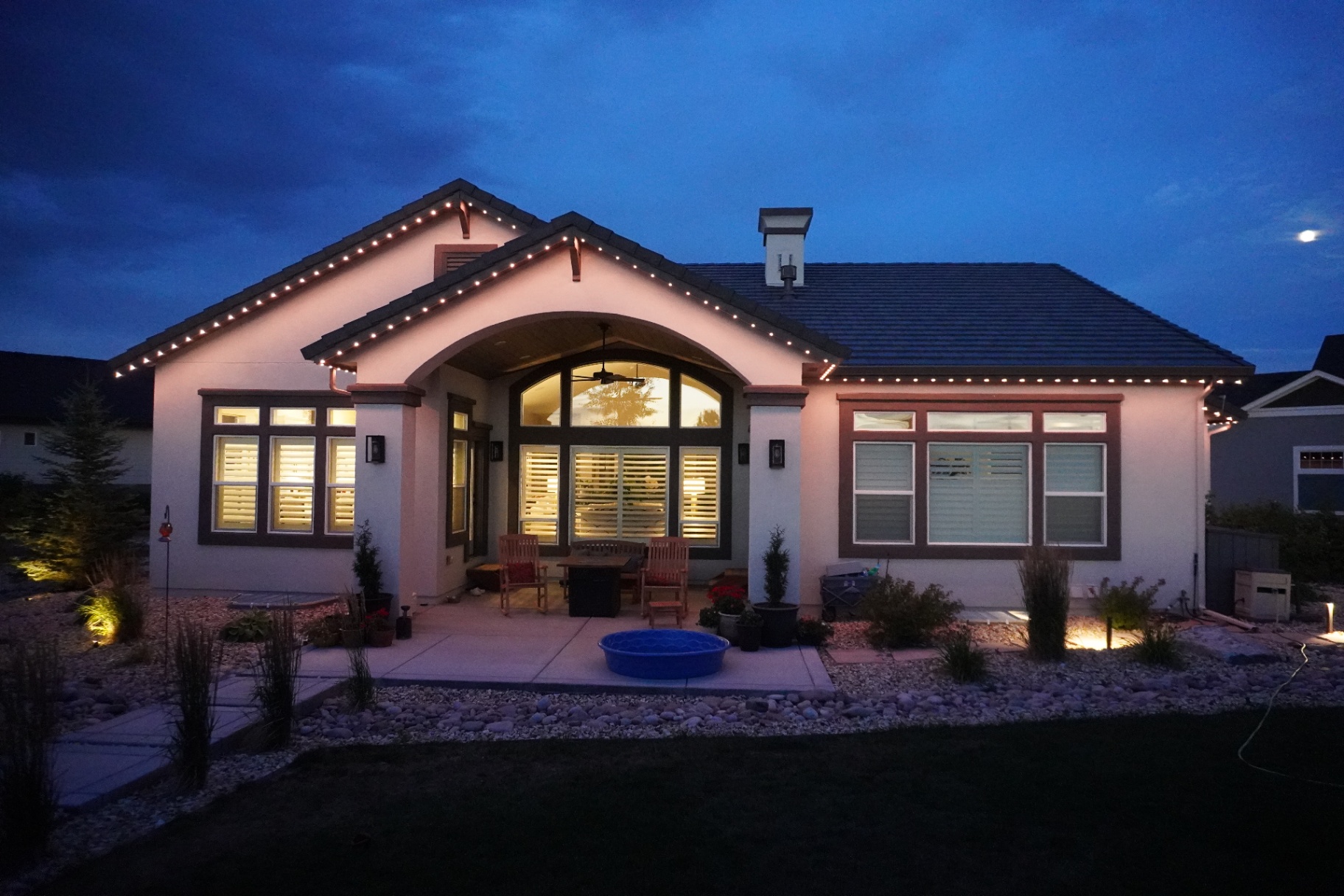 Warm white permanent lighting across a modern single-story home