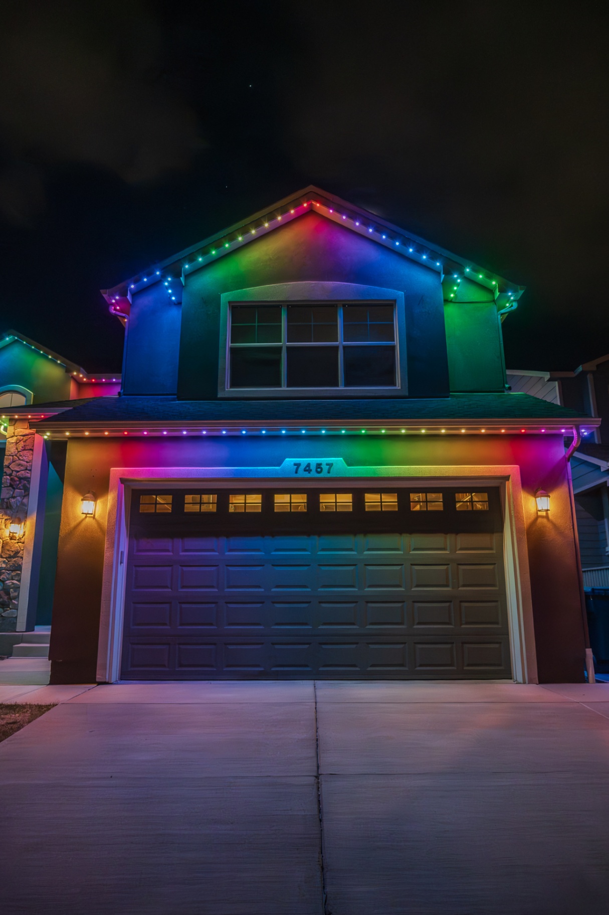Rainbow holiday lighting on a two-story home